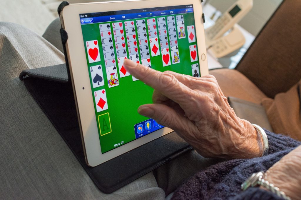 Elderly woman's hands playing electronic game at senior living community